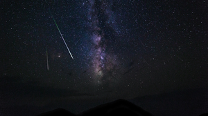Two meteor trails against a starry background in the night sky.